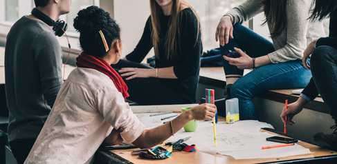 People sitting around table with paper and pens