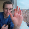 Nathaniel Wright holding a coin, with a university building in the background